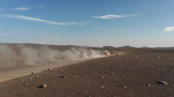 Drone melihat kendaraan off-road pada perjalanan gurun di Islandia. Menakjubkan pemandangan udara moonscape icelandic lanskap dengan mobil mengemudi debu jalan menjelajahi dataran tinggi. Asuransi komersial — Stok Video