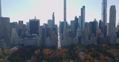 Central Park 'ın güney ucundaki görkemli gökdelenlerin panoramik görüntüsü. Parktaki ağaçların yaprakları sonbahar renginde. Manhattan, New York City, ABD