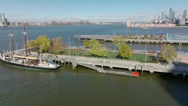 Vola intorno all'area sportiva sul molo 25 a Hudson River Park. Storica barca a vela in piedi all'ormeggio. Ampia superficie dell'acqua del fiume sullo sfondo. Manhattan, New York, USA — Video Stock