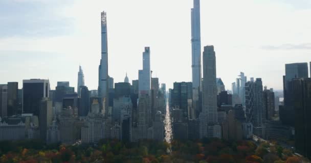 Высокие современные небоскребы и большие исторические здания в южной части Центрального парка. Вид на яркое небо. Манхэттен, Нью-Йорк, США — стоковое видео