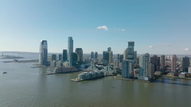 Вид с воздуха на высокие квартиры или офисные здания на набережной реки Гудзон. Два длинных пирса, выступающих в воду. Джерси-Сити, США — стоковое видео