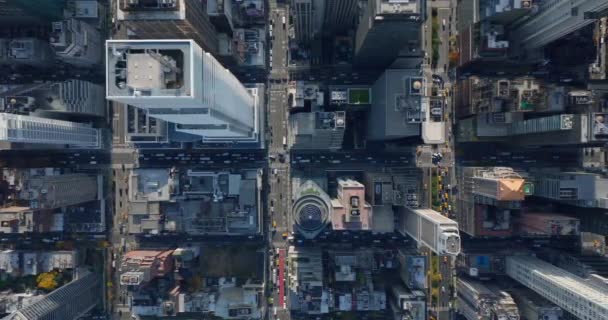 Luchtvogels oog boven hoofd naar beneden uitzicht op voertuigen rijden in brede straten op het passeren van kruispunten in de stad verdeeld in regelmatige blokken van gebouwen. Manhattan, New York City, Verenigde Staten — Stockvideo