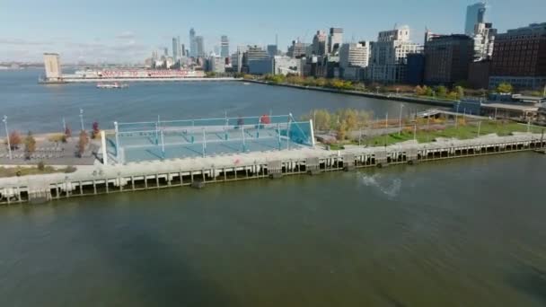 Voe sobre playgrounds esportivos em cais no rio Hudson. Edifícios altos e estrada movimentada à beira-mar. Manhattan, Nova Iorque, EUA — Vídeo de Stock