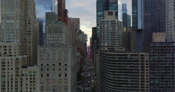 Przód przelatuje nad szeroką ulicą pomiędzy drapaczami chmur w centrum. Czerwone światła hamowania samochodów w oddali. Manhattan, Nowy Jork, USA — Wideo stockowe