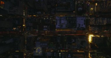 Havadan kuşların gözü tepeden aşağı akşam şehrini görüyor. Aydınlatılmış caddelerin ve yüksek binaların üzerinde uç. Manhattan, New York City, ABD