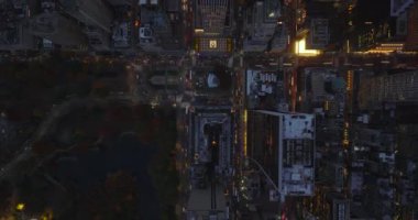 Gökyüzü kuşları tepeden aşağı şehirdeki akşam trafiğini görüyorlar. Yüksek binaların arasında yoğun yollar var. Manhattan, New York City, ABD