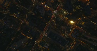Gökyüzü kuşları şehir merkezindeki akşam trafiğini yukarıdan izliyorlar. Yüksek binaların arasında düzenli olarak düzenlenmiş caddeler. Manhattan, New York City, ABD