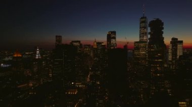 Alacakaranlıkta modern gökdelenlerin inanılmaz görüntüsü. Aşağı Manhattan 'daki binaların silueti renkli alacakaranlık gökyüzüne karşı. Manhattan, New York City, ABD