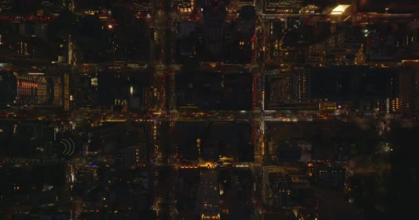 Повітряні птахи дивляться зверху вниз, статичний постріл вночі в центрі міста. Проїзд по освітлених вулицях між кварталами будинків. Мангеттен, Нью - Йорк, США — стокове відео