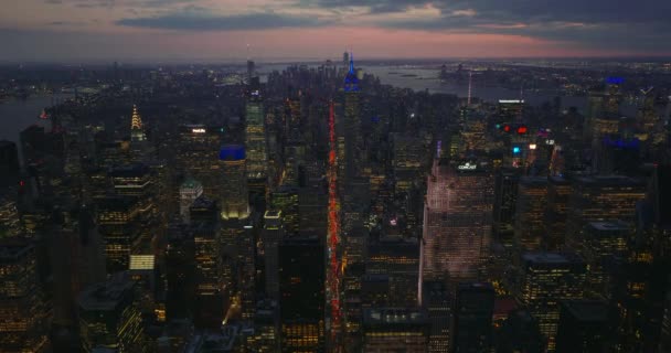 Avanti volare sopra il centro città sera con lungo viale dritto. Linea rossa delle luci dei freni sulla strada. Panorama della città al tramonto. Manhattan, New York, USA — Video Stock