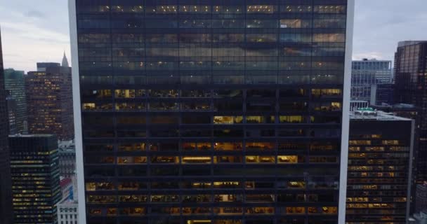 Voorwaarts vliegen tegen glazen muur van hoogbouw in de stad. Mensen die in kantoren achter ramen werken. Manhattan, New York City, Verenigde Staten — Stockvideo