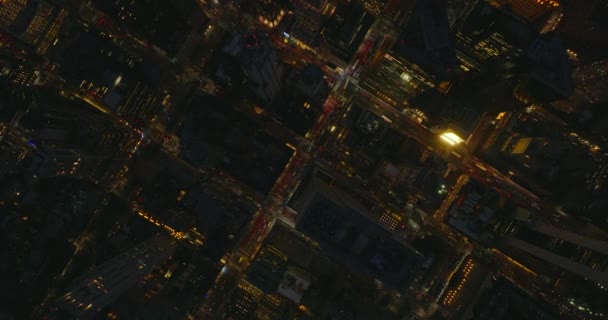 Les oiseaux aériens regardent en haut vers le bas des images de la circulation nocturne dans le centre-ville. Des rues régulièrement disposées entre des blocs de bâtiments de grande hauteur. Manhattan, New York, États-Unis — Video