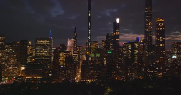 Escena nocturna. Edificios de gran altura y rascacielos del centro contra el cielo colorido. Edificios y calles iluminadas. Manhattan, Nueva York, Estados Unidos — Vídeos de Stock