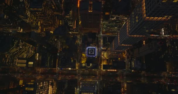Vogelbeobachtung über Kopf von oben nach unten Schwenkblick Nacht Stadt. Fliegen Sie um einen hohen modernen Wolkenkratzer, der über der geschäftigen Allee thront. Manhattan, New York City, USA — Stockvideo