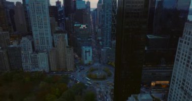 Şehir merkezindeki çok şeritli kavşağın yüksek açılı görüntüsü. Gün batımında Columbus Circle 'a giden araçlar. Manhattan, New York City, ABD