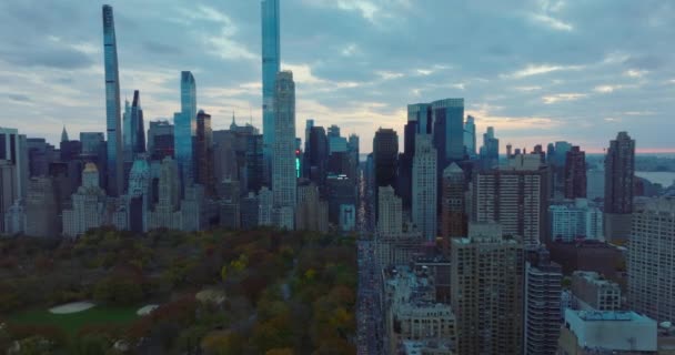 해질 무렵에는 가을 중앙 공원을 따라 날아 다닙니다. 공원 주변의 시내에 고층 건물들 이 공중에서 촬영되었습니다. Manhattan, New York City, USA — 비디오