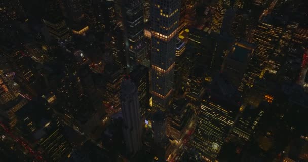 Al centro por la noche. Vista de ángulo alto de edificios de gran altura con ventanas iluminadas y calles iluminadas. Manhattan, Nueva York, Estados Unidos — Vídeo de stock