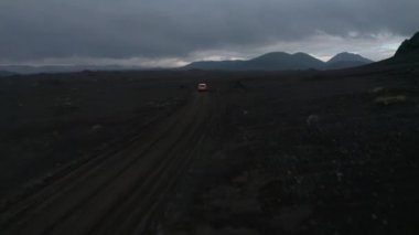Kuş bakışı araba İzlanda 'nın vahşi doğasında tek başına seyahat ediyor. Hava görüntüsü 4x4 İzlanda 'nın uzak hedefini keşfediyor. Güvenlik ve güvenlik. Macera ve keşif
