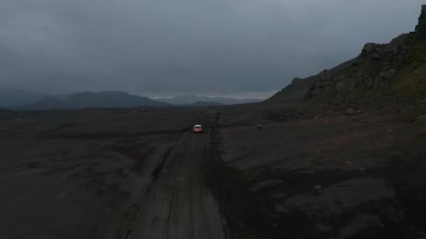 Amazing drone view moonscape icelandic landscape with vehicle driving dust road exploring highlands. Car 4x4 aerial view driving muddy path in Iceland. Commercial insurance — Stock Video