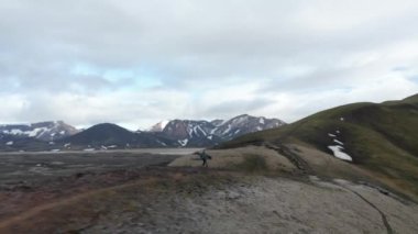 İzlanda 'daki dağ sırtında koşan sportif koşucu eğitiminin havadan görüntüsü. Kuş bakışı adam dağ yolunda koşuyor Skaftafell Ulusal Parkı 'nın tadını çıkarıyor