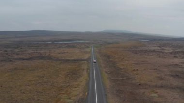 Top view otomobil pisti vahşi İzlanda kırsalını keşfediyor. Yüksek açılı manzara panoramik İzlanda dağları. Ticari sigorta. Doğada inanılmaz. Güvenlik ve güvenlik