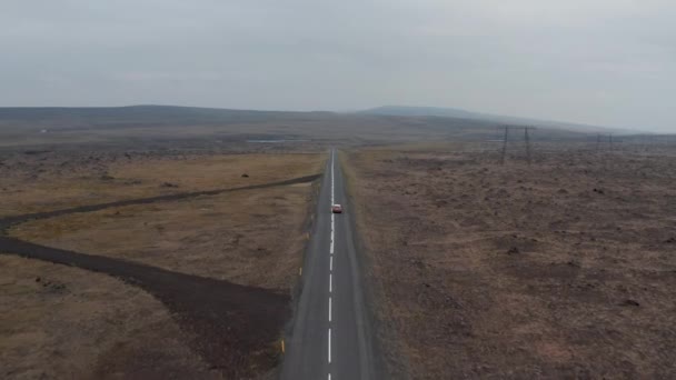 无人机看到四轮驱动的汽车沿着冰岛荒郊的高速公路行驶。高角镜威严的苔藓高地，汽车沿着环路行驶，是冰岛人最重要的公路 — 图库视频影像