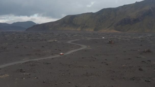 Drone ver coches que conducen camino de tierra en tierras altas icelándicas explorar. Drone view on offroad vehicle on desert road travelling in Iceland (en inglés). Aventura y exploración — Vídeos de Stock