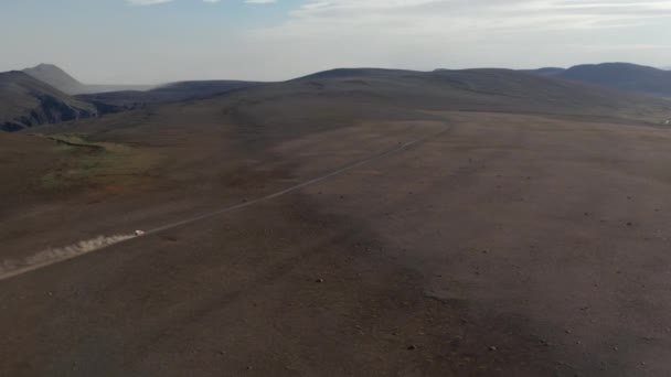 Aerial view car driving in desert stony highlands in Iceland. Drone view vehicle 4x4 speeding off road on pathway in rocky volcanic icelandic desert. Commercial insurance — Stock Video