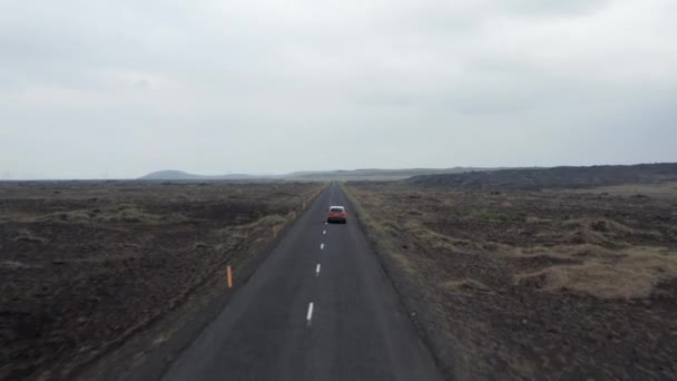 パノラマの高地とアスファルトの上でスピードアップ車を運転して、アイスランドで最初に鳥の目のビューの道路。環状道路で車の運転で風光明媚な風景のドローンビュー。冒険と探検 — ストック動画