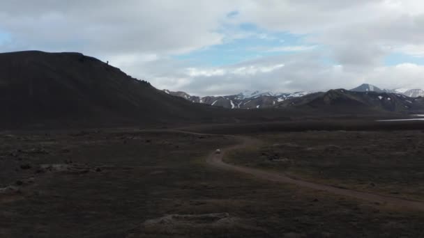 High angle view panorama of 4x4 vehicle driving offroad stony terrain exploring wilderness of icelandic highlands. Top view Skaftafell national park with snowy mountains and green moss countryside — Vídeo de Stock