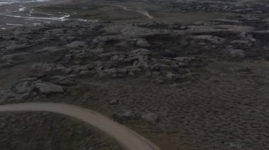 Muhteşem kuşların gözü İzlanda manzarası dağları ve toprak yol ve araba yolculuğu. Doğada güzellik. İzlanda kayalık kırsalının inanılmaz hava manzarası
