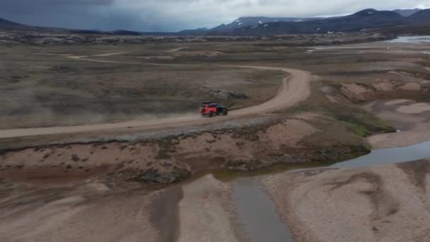 Widok z lotu ptaka poza jeepem jadącym dzikim krajobrazem, Islandia. Widok z lotu ptaka 4x4 pojazd pędzący przez mchy i pustynne tereny icelandyjskie. Przygoda i zwiedzanie. Cel podróży — Wideo stockowe