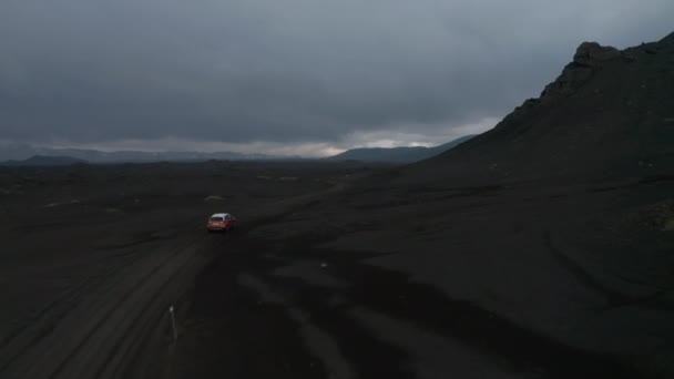 Birds eye view following car driving Iceland mossy and muddy highlands exploring wilderness. Amazing aerial view moonscape icelandic landscape with 4x4 vehicle driving dust road exploring country — Stock Video
