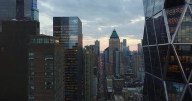 Şehir merkezindeki modern gökdelenlerin tersten görünüşü. Trafikle dolu uzun ve düz bir caddenin üzerinde uç. Alacakaranlıkta şehir. Manhattan, New York City, ABD