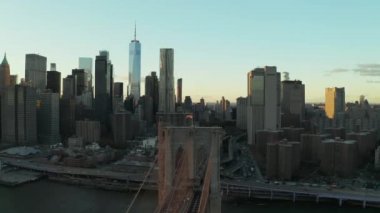 Köprü süspansiyon kulesinin üstünde Amerikan bayrağı olan görüntülerini kaydır. Şehir merkezi gökdelenleri olan şehir manzarası. Manhattan, New York City, ABD