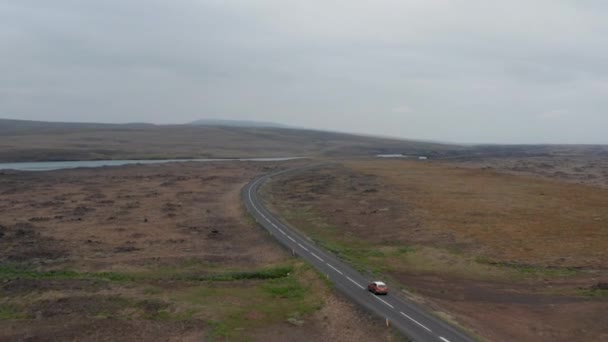 High angle view majestic landscape panorama of iceland countryside in cloudy day with car driving ring road. Top view of drone following car driving in rock desert in isolated volcanic Iceland — 图库视频影像