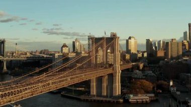 Brooklyn Köprüsü 'nün etrafında devasa taş sütunlar ve destek kablolarıyla yükselen ileri uçaklar. Arka planda şehir mahallesi. Brooklyn, New York City, ABD