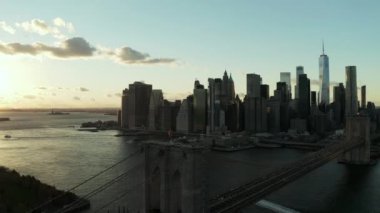 Brooklyn Köprüsü 'nün üzerinden uç, ufuk çizgisiyle. Gün batımına karşı ofis gökdelenlerinin siluetleri. Manhattan, New York City, ABD