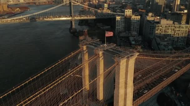 Increíble vista aérea del puente de Brooklyn al atardecer. Torre de suspensión y cables iluminados por el sol brillante. Ascendente inclinación hacia abajo tiro. Brooklyn, Nueva York, Estados Unidos — Vídeos de Stock