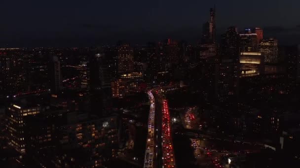 Вид с воздуха на интенсивное движение на улицах ночного города. Высотное здание с освещенными окнами. Бруклин, Нью-Йорк, США — стоковое видео
