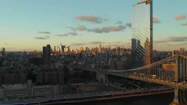 Sliding revel of waterfront with busy road. Bridge, high rise building with glossy facade and skyline with skyscrapers in background. Manhattan, New York City, USA — Stock Video