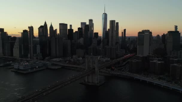 Skyline of tall modern downtown skyscrapers in Financial District against twilight sky. Business borough and Brooklyn Bridge at dusk. Manhattan, New York City, USA — Vídeo de Stock