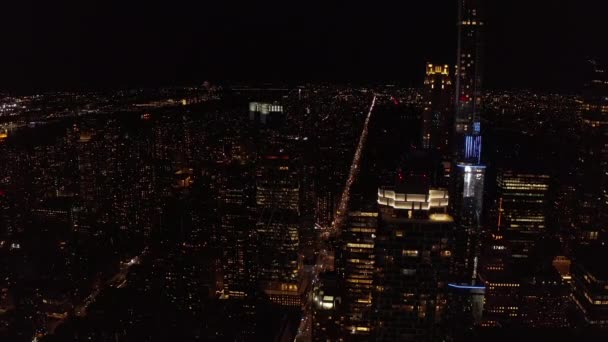 Fliegen Sie über Nacht Stadt. Moderne Hochhäuser in der Innenstadt. Beleuchtete Fenster in Hochhaustürmen. Manhattan, New York City, USA — Stockvideo