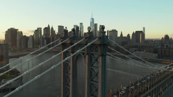 Повітряний вид вежі підвіски і підтримка кабелів зайнятого Манхеттенського мосту в сутінках. Центральні хмарочоси в фінансовому районі. Мангеттен, Нью - Йорк, США — стокове відео