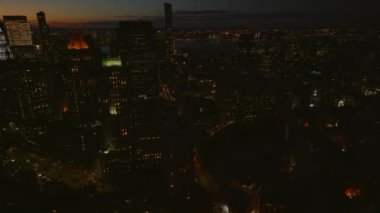 Gece şehrinin üzerinde uç. Gün batımından sonra şehir merkezinde yüksek binalar. Manhattan, New York City, ABD