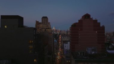 Yüksek binalar arasındaki kalabalık Broadway caddesinin üzerinde ilerliyorlar. Aydınlatılmış gökdelenlerle gökyüzü aydınlanıyor. Manhattan, New York City, ABD