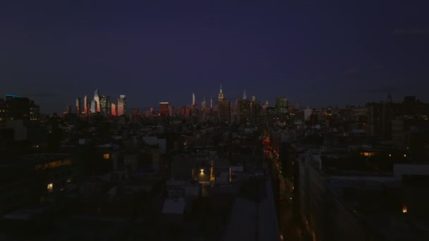 Forwards fly above evening city. Illuminated downtown skyscrapers at dusk in distance. Manhattan, New York City, USA — Stock Video