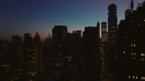 Vzestupné letecké záběry města za soumraku. Siluety mrakodrapů v centru města proti barevné soumračné obloze. Manhattan, New York City, USA — Stock video