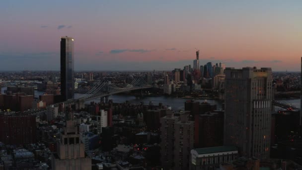 Aerial descending footage of town development in Lower Manhattan. View of bridges and high rise buildings in Brooklyn in twilight time. Manhattan, New York City, USA — 图库视频影像