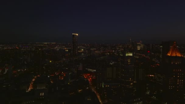 Vpřed letí nad noční město. Osvětlené ulice a vysoké budovy. Letecký pohled na mosty do Brooklynu. Manhattan, New York City, USA — Stock video
